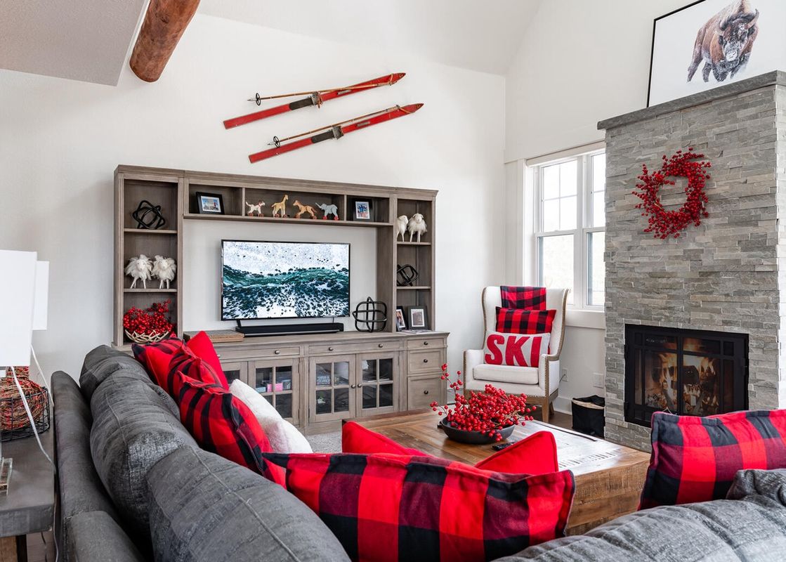 Moonlight Basin Saddle Ridge D1 living room with fireplace, large TV, and a comfortable sofa with red pillows.