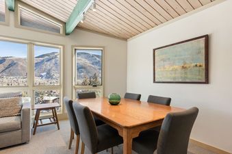 Dining table and chairs in Shadow Mountain Unit 19 with mountain views through the windows.