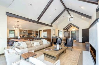 An inviting living space with a high ceiling, a comfortable seating arrangement, and a view into the modern kitchen.