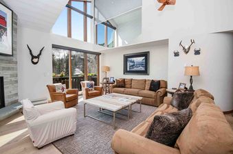 The living area of the Village Inn Plaza 109 with large windows showcasing mountain views.