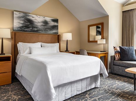 A cozy bedroom in The Westin Resort Deluxe Studio Suite Mountain View features a comfortable bed, stylish furnishings, and a scenic mountain view from the window.