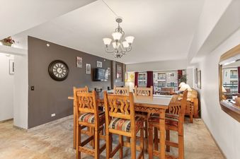 A wooden dining table with six chairs in a living room.