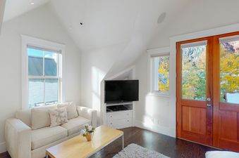 Living room area in Depot 417 with white couch and wood floors.