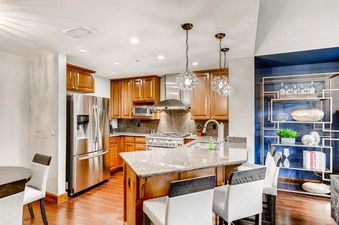 A modern kitchen with stainless steel appliances, granite countertops, and a breakfast bar.