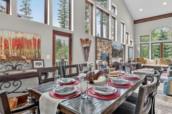 The living area within the Ski Hill Sanctuary features a dining table set for guests and comfortable seating arrangements.