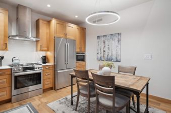 Riverfront Lodge 401 features a fully equipped kitchen with stainless steel appliances, a dining table for four, and hardwood floors.