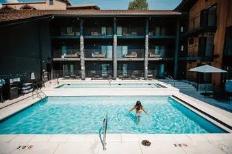 A guest wading in the outdoor pool at Gravity Haus JH Deluxe Suite.