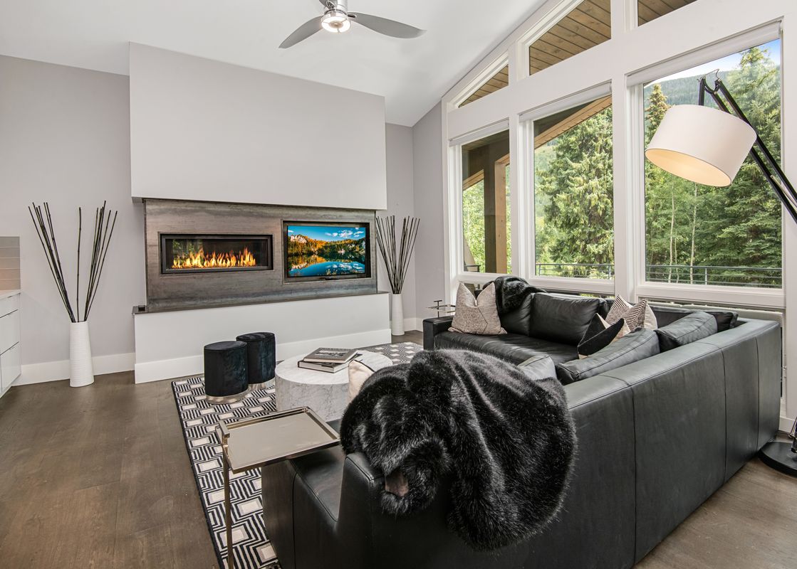 The living room in Apres Chalet Vail showcases a fireplace and television for a cozy ambiance.