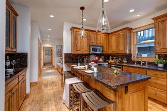 The kitchen in Winter Mooring Old Town boasts stunning countertops and wooden cabinetry.