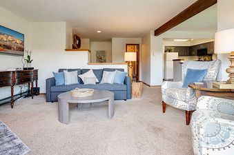 A cozy and inviting living room at Ranch at Steamboat RA219 with a gray sofa, two patterned armchairs, and a flat-screen TV.