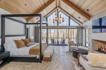 A beautiful bedroom at Lone Star Lodge with a fireplace and windows with a scenic view.
