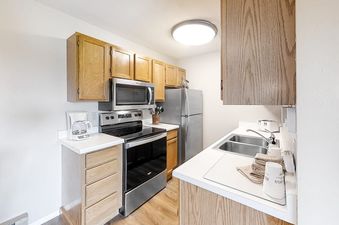 Fully-equipped kitchen at Ski Inn Condominium 221 featuring wooden cabinetry and stainless steel appliances.