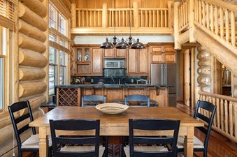 The dining area in Wild Bear Haven features a wooden table and chairs.