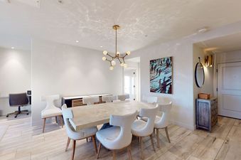 The modern dining area at Torian Plum Creekside 714 featuring a large wooden table and stylish white chairs.