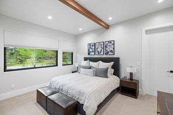 The bedroom at Fairway Cabin Two Bedroom with Golf View featuring a large bed, windows with a view, and modern decor.