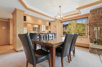 A dining room in Lodge Tower 377 3BR is lit by a chandelier.