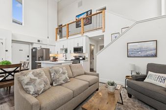 An inviting open-concept living space in Quarry B10 with a modern kitchen, comfortable living room, and high ceilings with natural light.