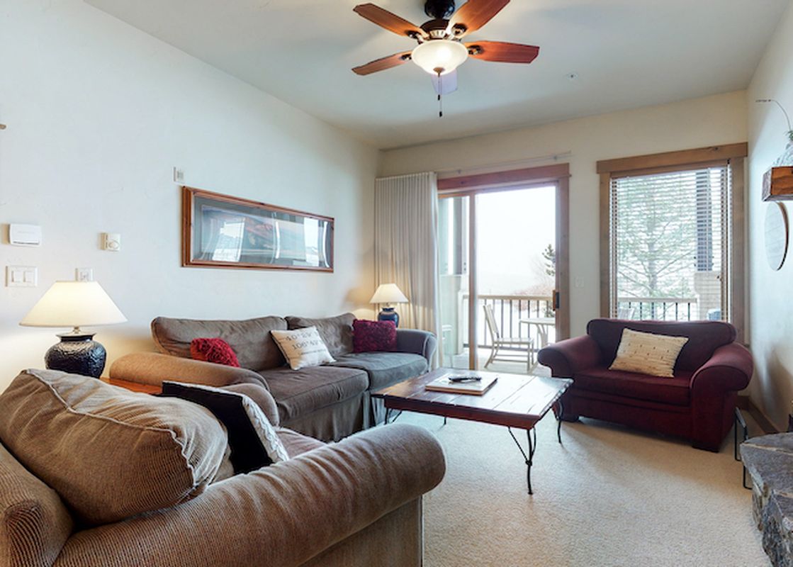 The living room of EagleRidge Lodge 300 features a fireplace, a sofa, two chairs, a coffee table, and a window with an exterior view.