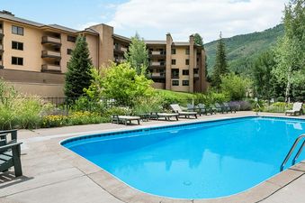 A sunny view of the pool at Fallridge, with lounge chairs lining the edge.
