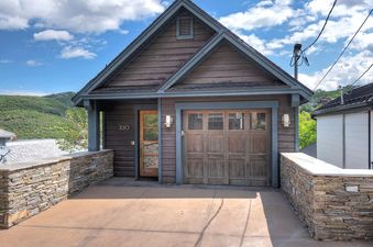 The exterior of Dwell on Woodside showcases a charming garage and stone retaining wall.