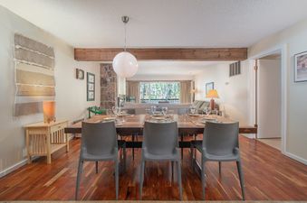 Dining area of Whiteridge B1 showing the dining table set for six, leading into the living room.