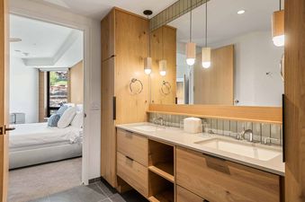 The bathroom at Electric Pass Lodge 207 features a double vanity with two sinks, a large mirror, and wooden cabinetry.