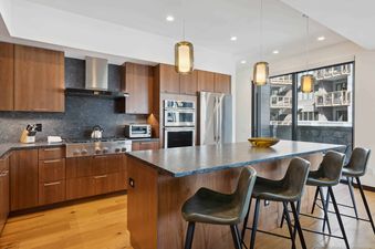 The kitchen of The Lion W302, featuring stainless steel appliances, a large island, and a view of the mountains from the window.