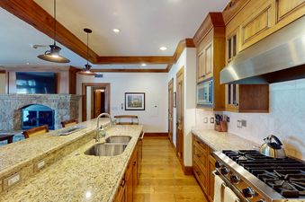 The kitchen at Top of the World at Bachelors Gulch features stainless steel appliances, granite countertops, and wooden cabinets.
