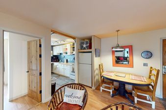 A cozy living room area in Beaver Creek Basecamp with a dining table, two chairs, and a large window.