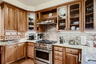 The kitchen at Moose on the Loose features light wooden cabinetry, granite countertops, and stainless steel appliances.