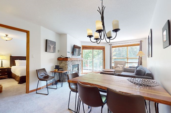 The dining area seamlessly connects to the living room and features a large wooden table with several brown chairs, creating an inviting space for meals and relaxation.