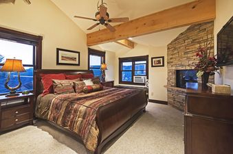 Bedroom at Big Game Lodge Park City with a king size bed and a stone fireplace.