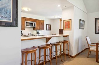 Kiva 428 features a modern kitchen with stainless steel appliances and a breakfast bar with bar stools.