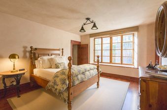 A bedroom with a wooden bed and a window with a view of the outdoors