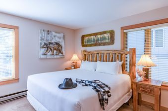 Cozy bedroom in Rendezvous D1 with a log bed and rustic decor.