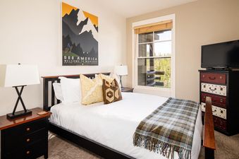 Bedroom in Moonlight Basin Saddle Ridge D3 with a king-size bed, nightstands, and a dresser with a television on top.