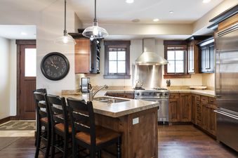 The kitchen at Silver Star 603 features dark wood cabinets, granite countertops, and stainless steel appliances, including a large range and a refrigerator.