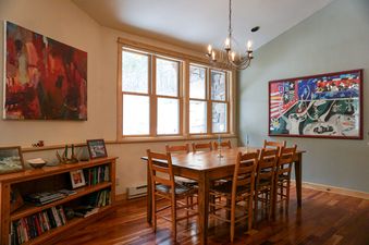 An elegant dining space in Moose Creek 27 featuring a wooden table set for six under a classic chandelier.
