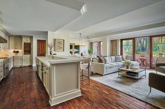 A spacious Montage Four Bedroom Residence Resort View unit featuring a fully equipped kitchen, a comfortable living area, and a balcony with lush forest views.