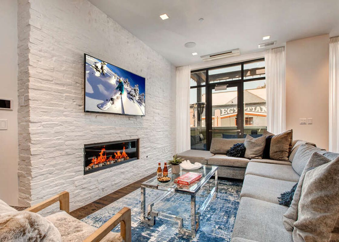 The Abode at Parkite 24's contemporary living room features a sleek fireplace and large sectional sofa.