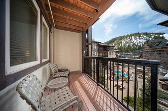 The balcony at Fraser Crossing 3509 with a view of the mountains and pool.