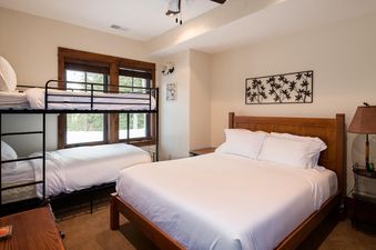 A bedroom at Moonlight Basin 20 Peaks View, featuring a king-size bed with white linens and a bunk bed for two.