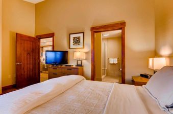 The bedroom in One Ski Hill Penthouse features a comfortable bed and en-suite bathroom.