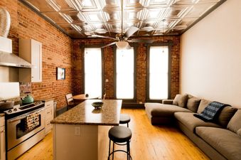 Sunny Downtown Condo above the Coffee Shop living room with a couch and a view of the kitchen.