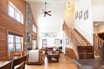 A spacious and inviting living area in Rendezvous 25 Discovery Lane, featuring high ceilings, a stone fireplace, and comfortable furnishings.