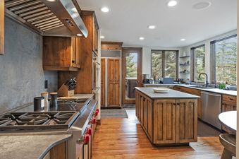 The kitchen at Antlers Estate features a large wooden island, stainless steel appliances, and a gas stove.
