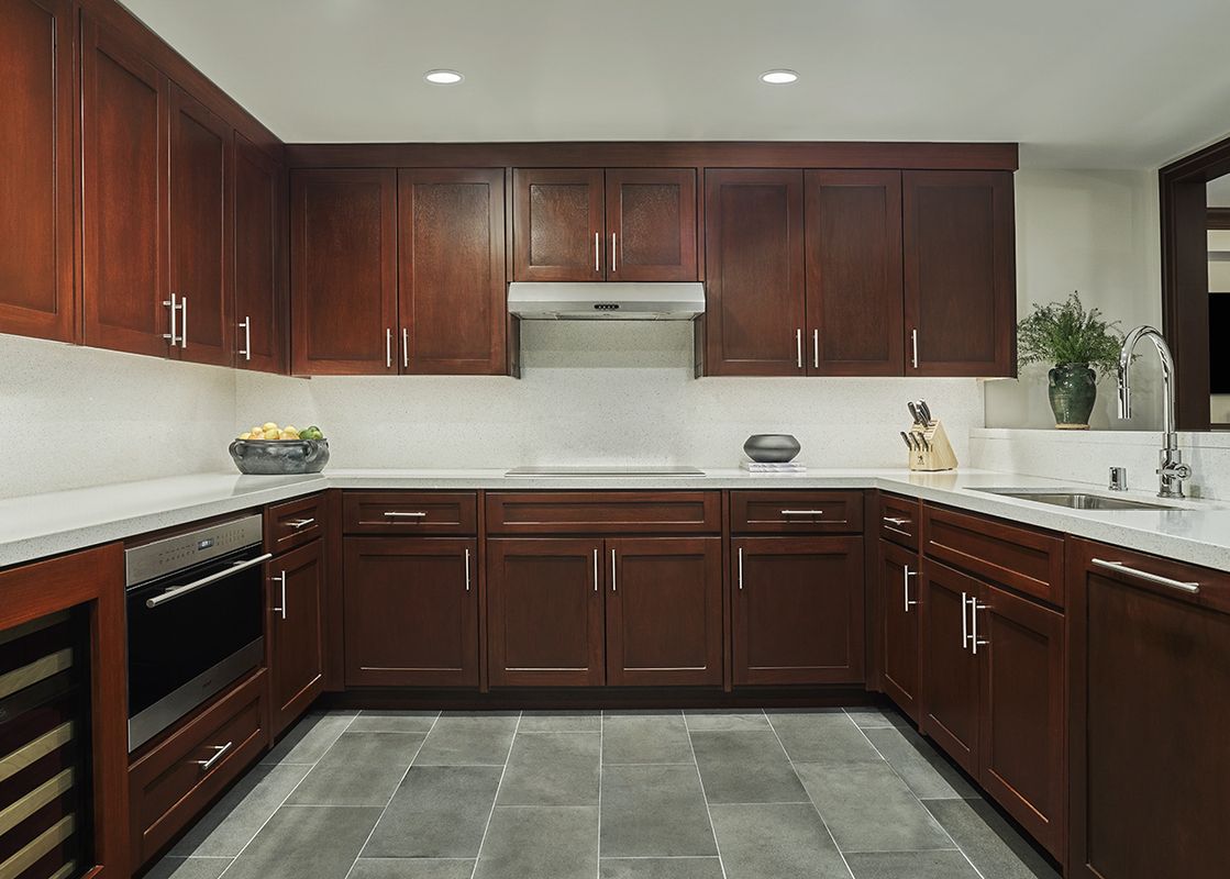The contemporary kitchen in Montage Alpine Residential Suite features rich wooden cabinetry, light countertops, and modern appliances.