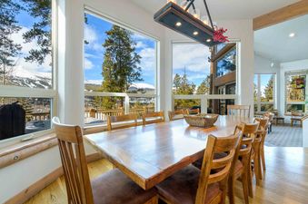 The dining area at Aspenglow Chalet Above Downtown features large windows and a spacious table.