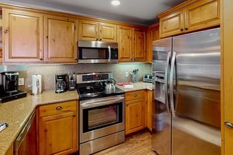 The kitchen in EagleRidge Lodge 203 has stainless steel appliances and wood cabinets.
