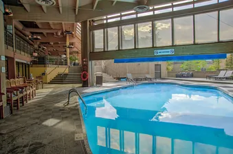 An inviting indoor swimming pool at Summit Suite Beaver Run Resort with sparkling blue water and large windows.